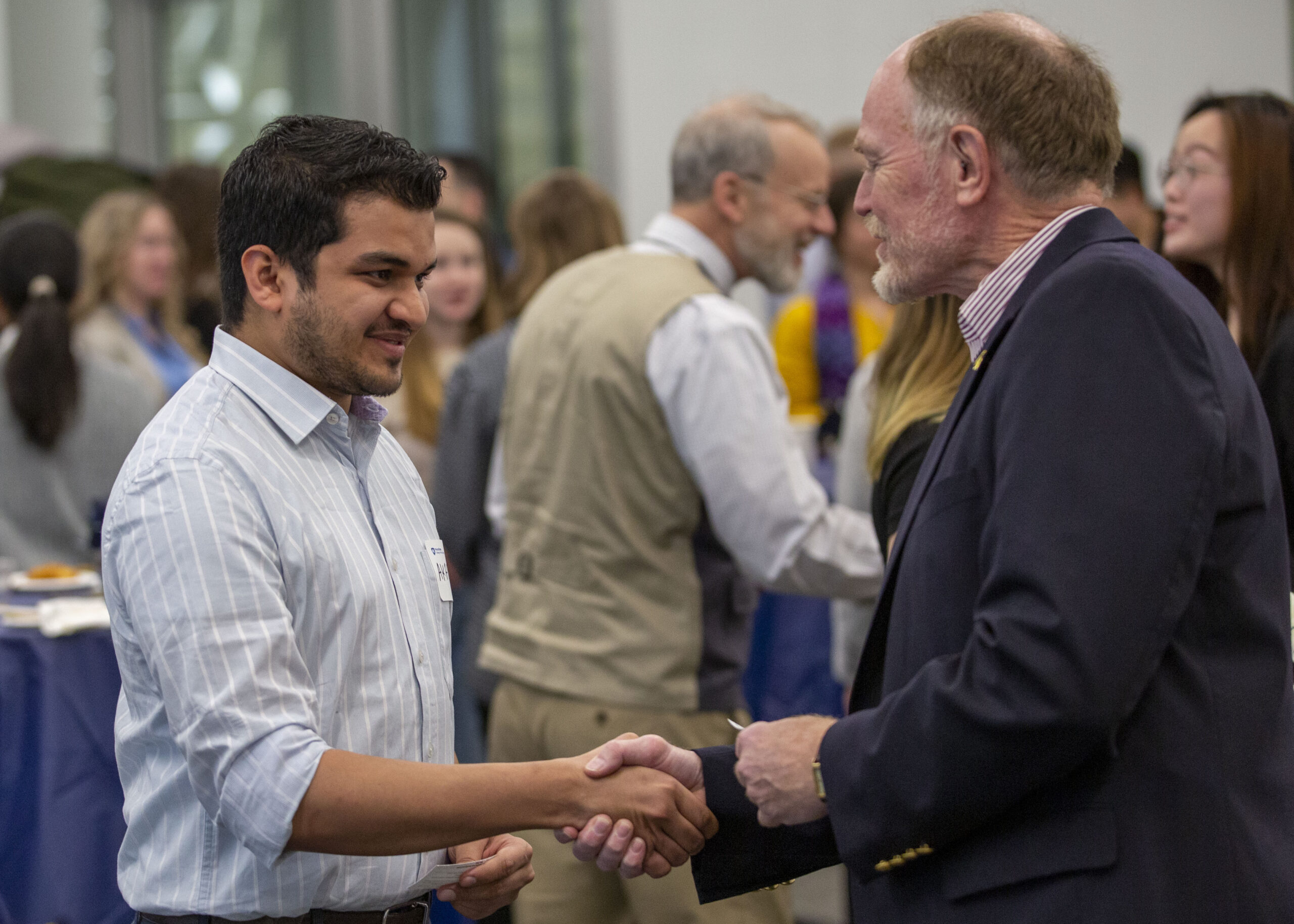 A Liberal Arts student (left) shakes hands with alumnus Jeff Hyde (right) at a Liberal Arts Career Week event in January 2020.