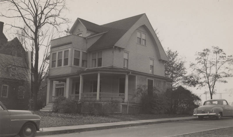 Cars are parked on the street next to the south entrance of Ihlseng Cottage in 1951