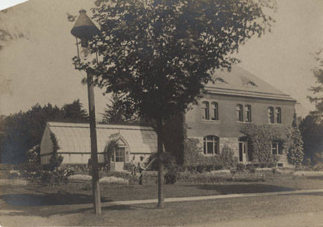 Three people tend to the gardens outside Old Botany Building in 1893.