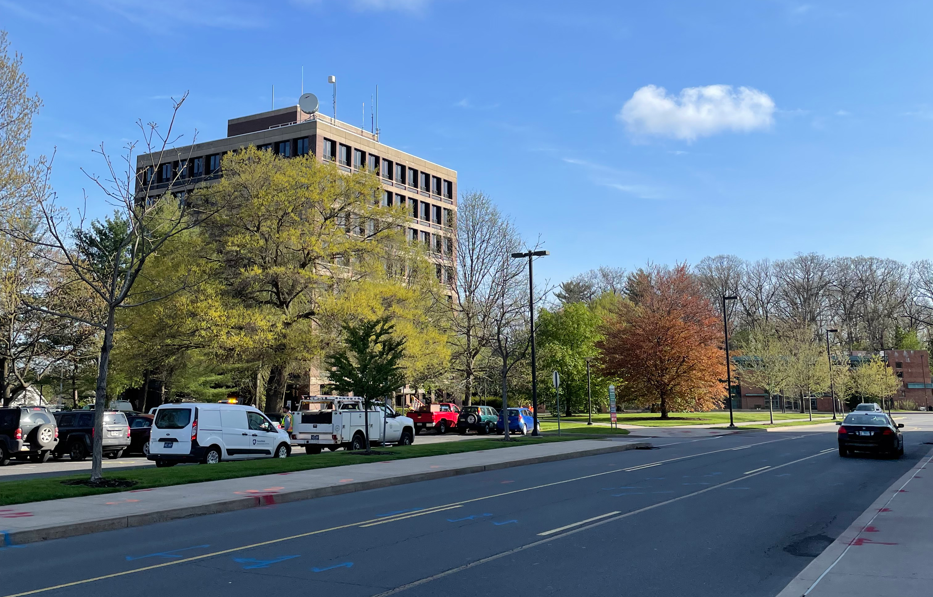 A parking lot with Ford Building in the background, taken in May 2022. This is the future site of the Welch Building.