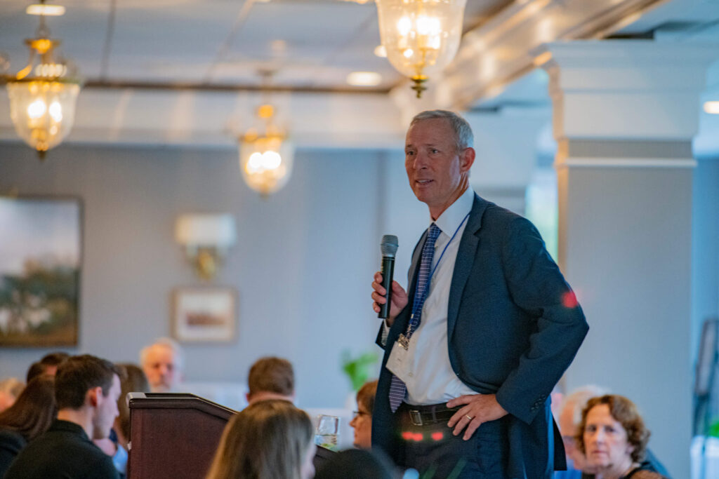 Randy Sones stands with a microphone at the 2022 Alumni Awards Ceremony