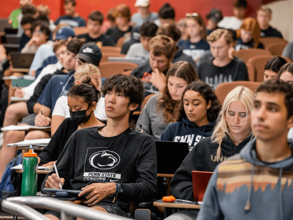 Penn State students take notes during an economics class in 121 Sparks Building in October 2022.