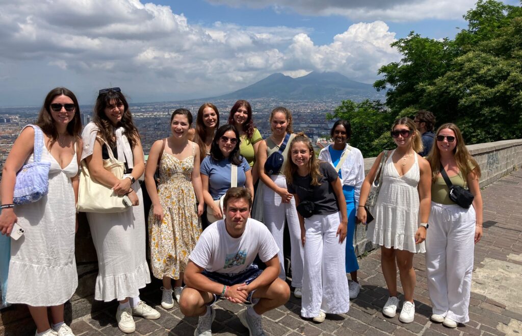 Students in Salerno, Italy, pose for a photo in front of Mount Vesuvius after spending the day exploring and checking out art museums.