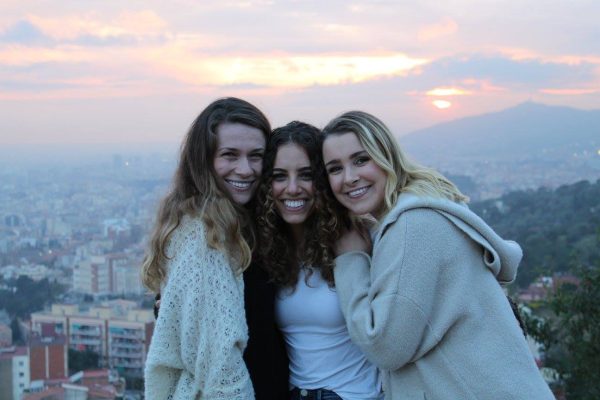 Three Liberal Arts students embrace and smile at the camera while studying abroad in Spain.