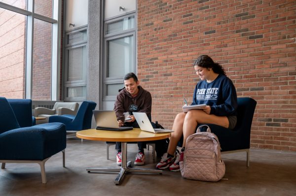 Michael Garza (left) and Haley Parker (right) do coursework on their laptops and notebooks while sitting in a lounge in Moore Building.