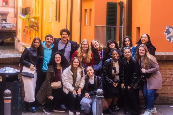 A group of students poses in a colorful alleyway in Bologna, Italy.
