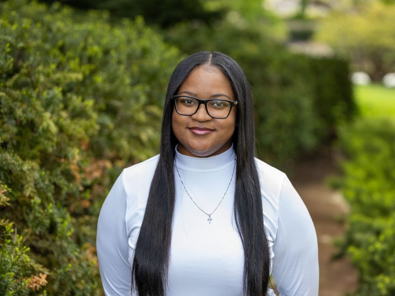 Cameryn Allen, who graduated Penn State in 2025, smiles wearing a long-sleeve white shirt and glasses.