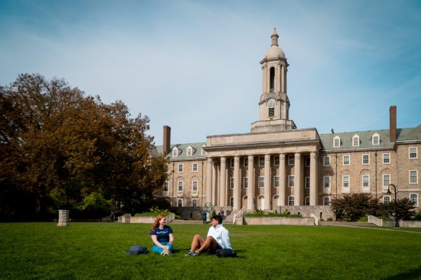 Liberal Arts students Casey Sennett (left) and Ima Bazan (right) sit on Old Main lawn in October 2022