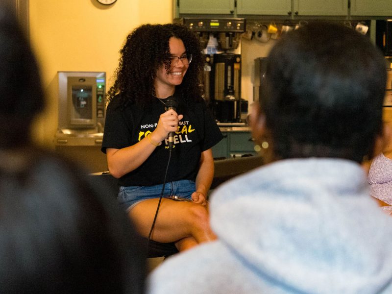 Lenneya Murray, who will graduate from Penn State in 2025, smiles while holding a microphone.