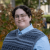 Felicity Sarnoff, who is the Penn State College of the Liberal Arts as college marshal for the fall 2024 commencement ceremony, stands in front of trees and bushes at Penn State University Park.