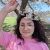 Ye Eun (Esther) Lee Ye Eun (Esther) Lee) wearing a light pink T-shirt and standing in front of a blossoming cherry tree